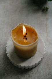Top view of a lit Busy Bees 3 Inch by 3.5 Inch pillar candle showing the melted wax and flame detail.