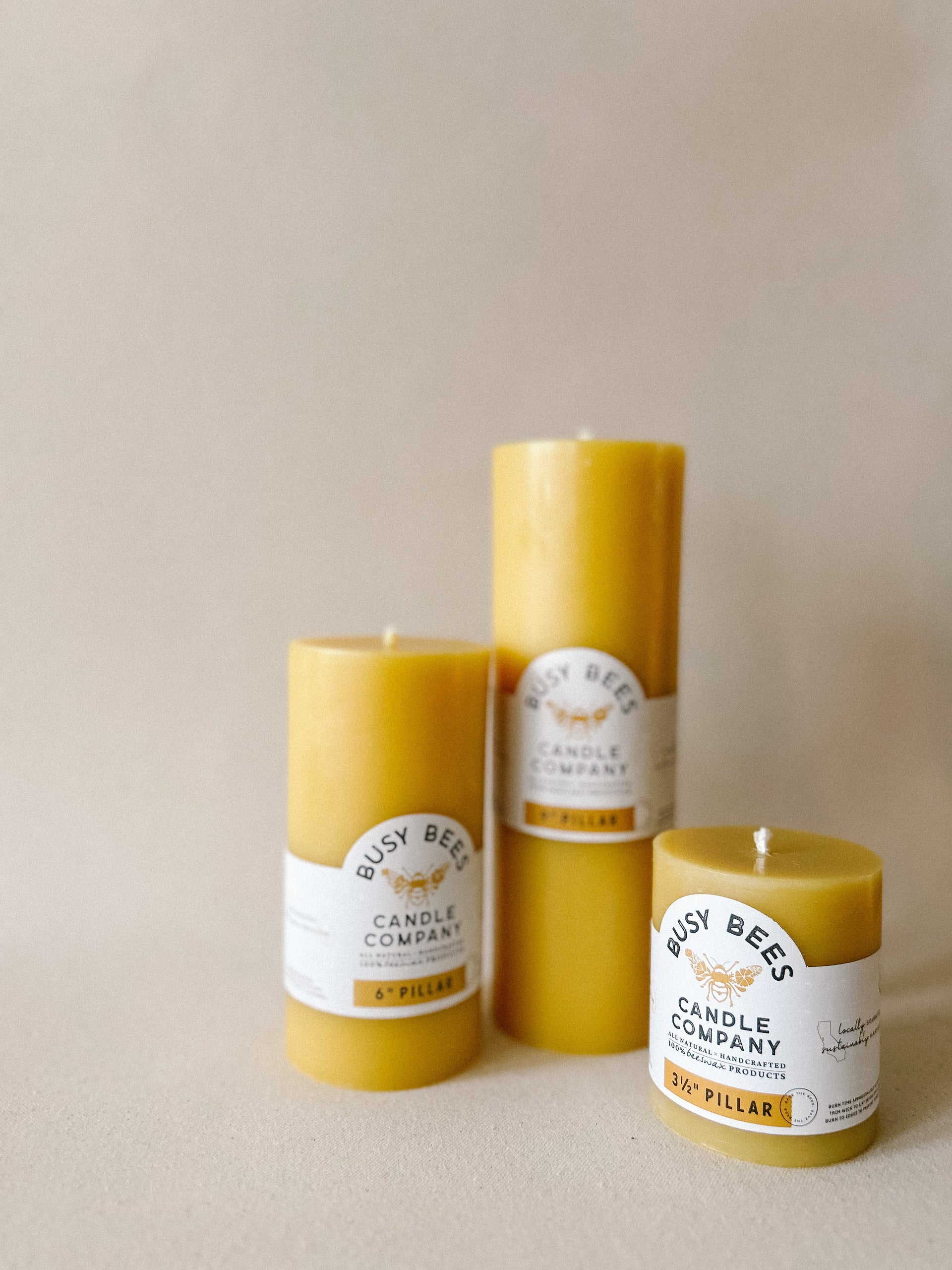 Busy Bees 3 Inch Pillar Trio featuring three natural yellow beeswax pillar candles arranged together against a soft neutral background.