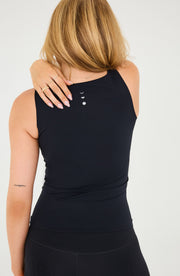 Back detail of the Elastique Athletics Iconic MicroPerle Tank in black highlighting the racerback cut and centered logo detail.