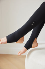 Close up detail of the Elastique Athletics L'Original Lymphatic Stirrup Leggings in black showing the stirrup foot strap design and seamless ankle fit.