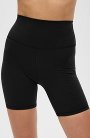 Close up front detail of the Elastique Athletics L'Original Lymphatic Bike Short in black highlighting the high waisted fit and smooth silhouette.