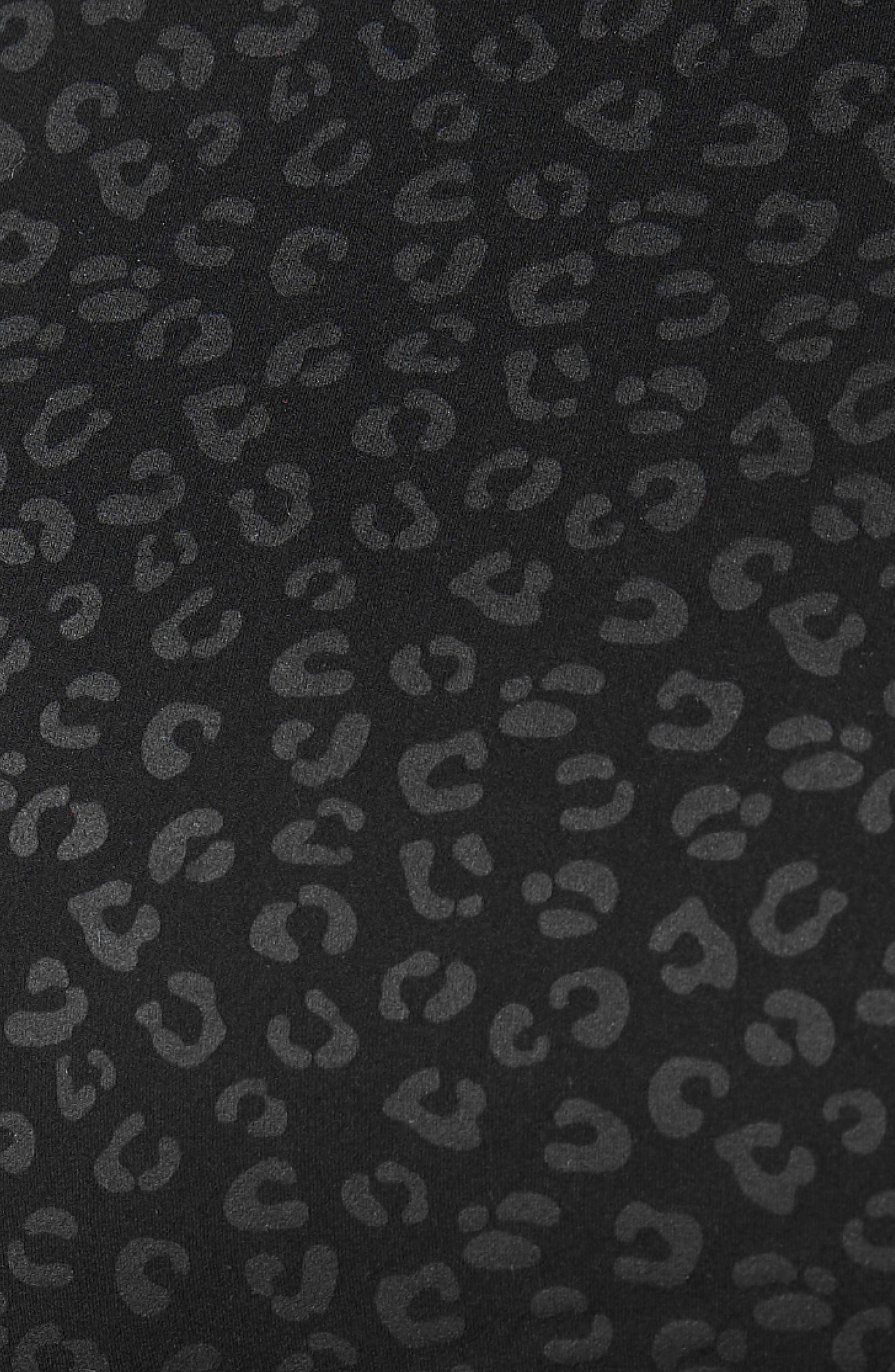 Close up fabric texture detail of the Elastique Athletics The Fierce Tank featuring a tonal black leopard print pattern.