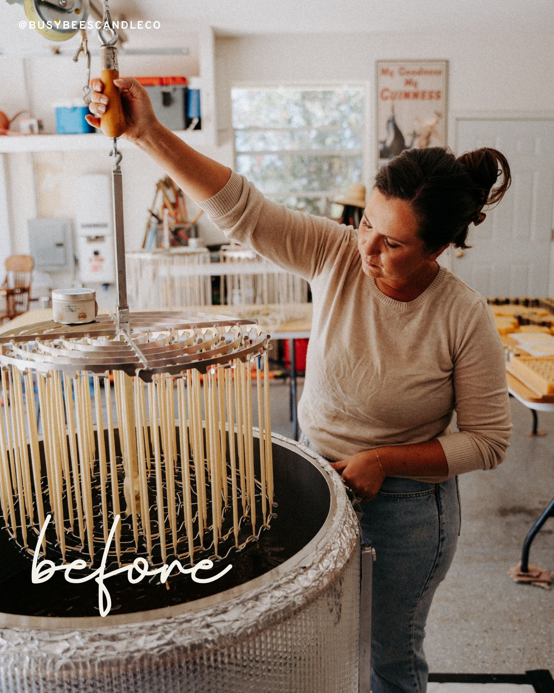 Person arranging multiple lit Busy Bees Hand Dipped 12 Inch Taper Candles on a dining table in a softly lit room.