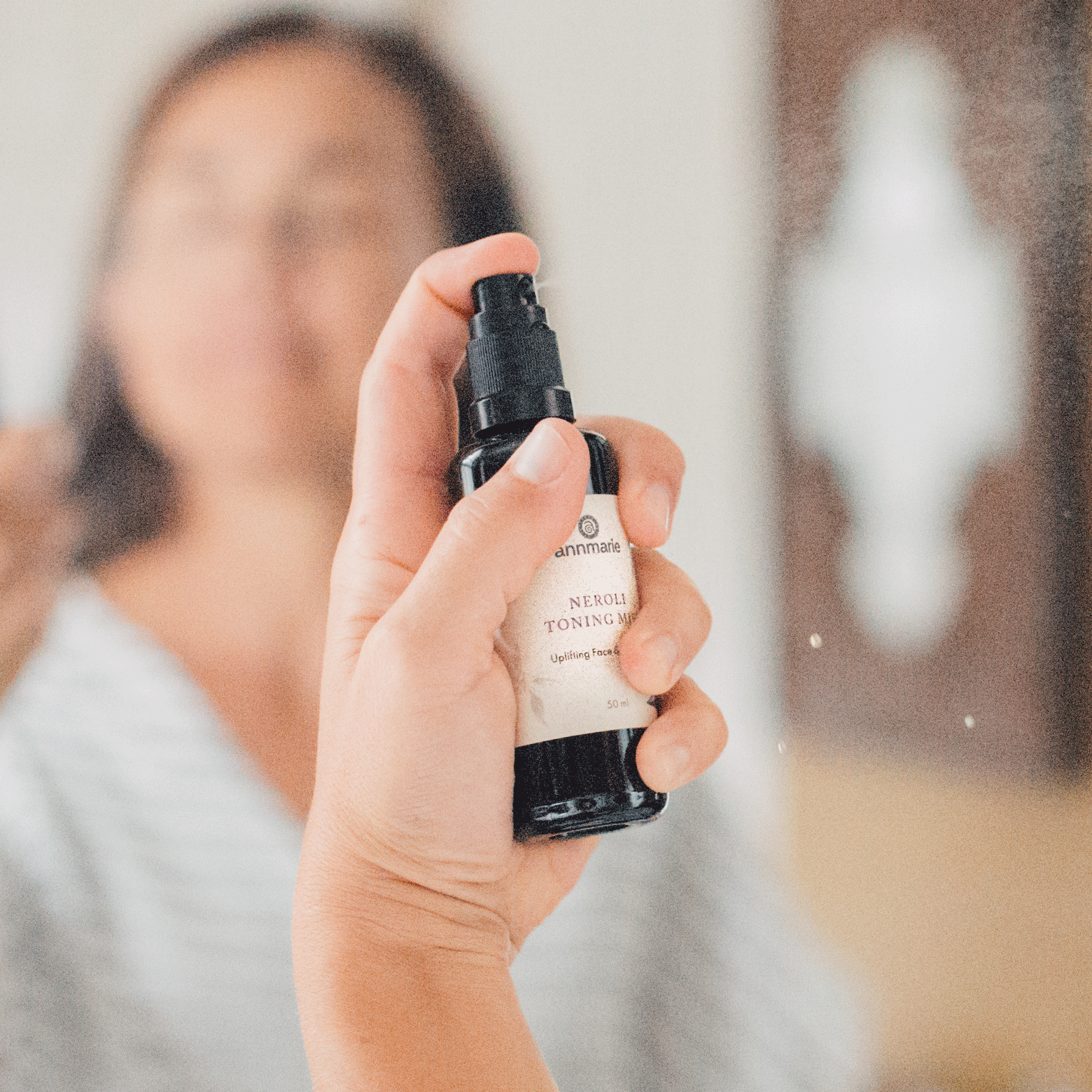 Woman applying Annmarie Neroli Toning Mist facial spray during a natural skincare routine