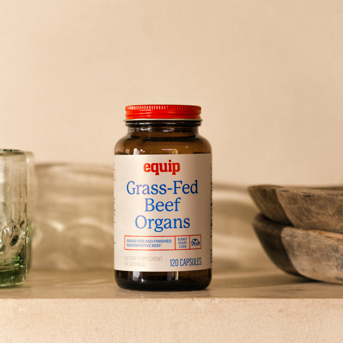 Equip Grass-Fed Beef Organs supplement, 120-capsule amber glass bottle on a stone shelf