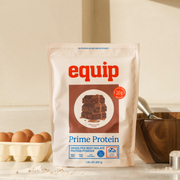 Equip Prime Protein low-sugar chocolate bag with chocolate pieces and a protein drink