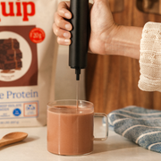 Equip Prime Protein chocolate bag with a protein shake and woman in a kitchen