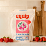 Equip Prime Protein strawberry bag with fresh strawberries on a kitchen counter