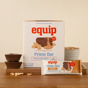 Equip Prime Bar peanut butter chocolate protein bars displayed with peanut butter and chocolate