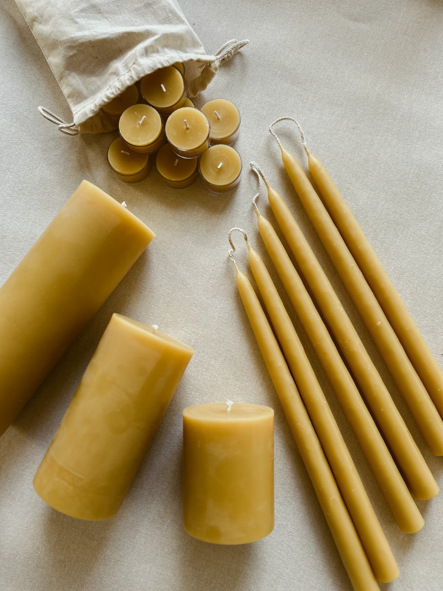 Busy Bees The Queen Bee Bundle featuring beeswax pillar candles, taper candles, and tea lights arranged together on a soft neutral surface.
