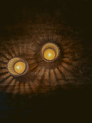 Overhead view of lit Busy Bees Ribbed Glass Tea Light Holders creating circular light reflections in a dark room.
