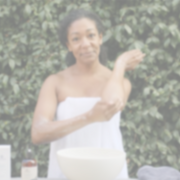 Woman using botanical body care products as part of a daily self-care routine