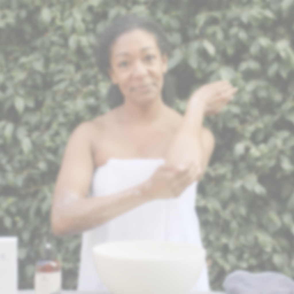 Woman using botanical body care products as part of a daily self-care routine