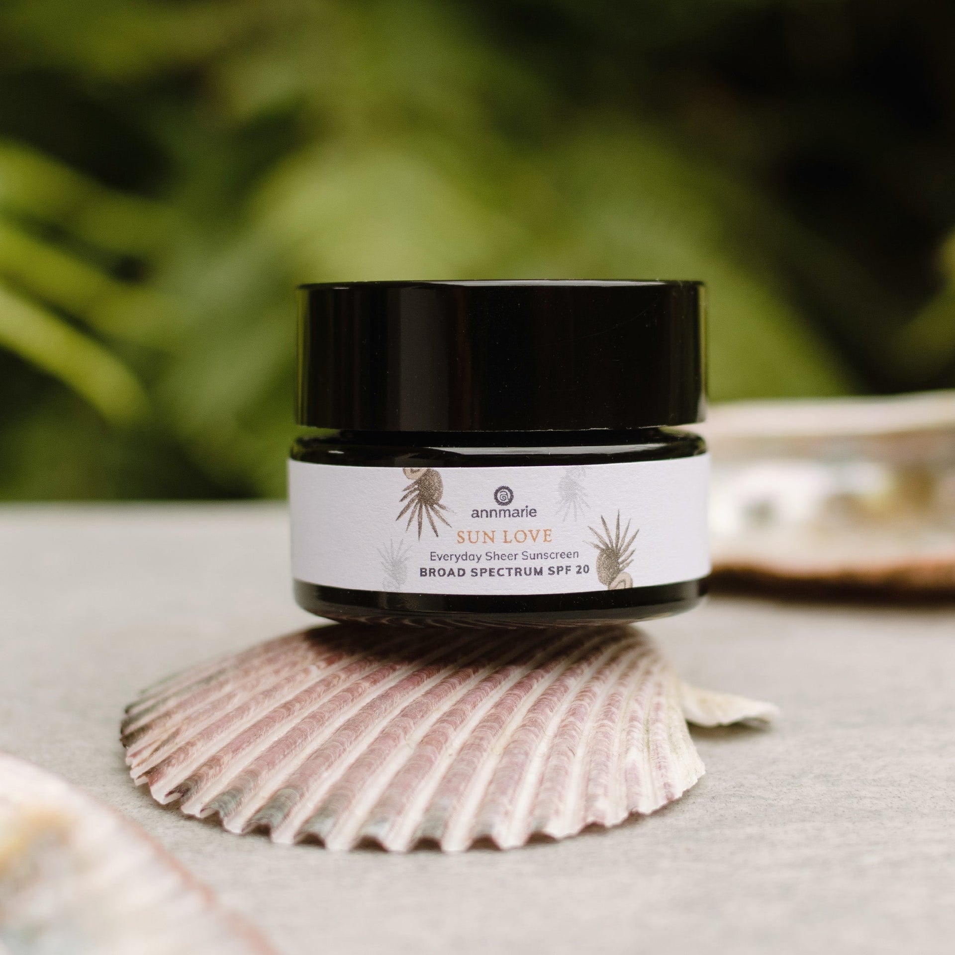 Annmarie Deluxe Mini Sun Love sunscreen jar displayed outdoors in natural light