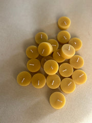 Busy Bees Bulk Loose Tea Light Candles arranged in a clustered flat lay on soft neutral fabric.