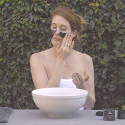 Woman applying Charcoal Cacao Mask as part of a weekly skincare ritual