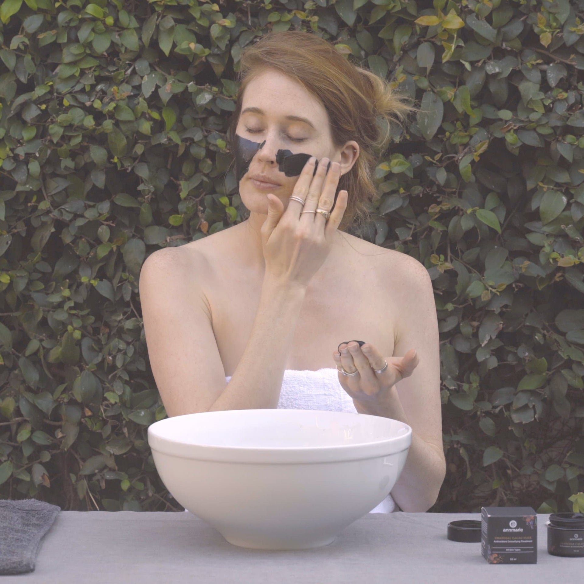 Woman applying Charcoal Cacao Mask as part of a weekly skincare ritual