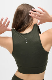 Back view of a woman wearing the Elastique Athletics Le Divine Lymphatic Bra in olive green showing the racerback design and seamless fit.