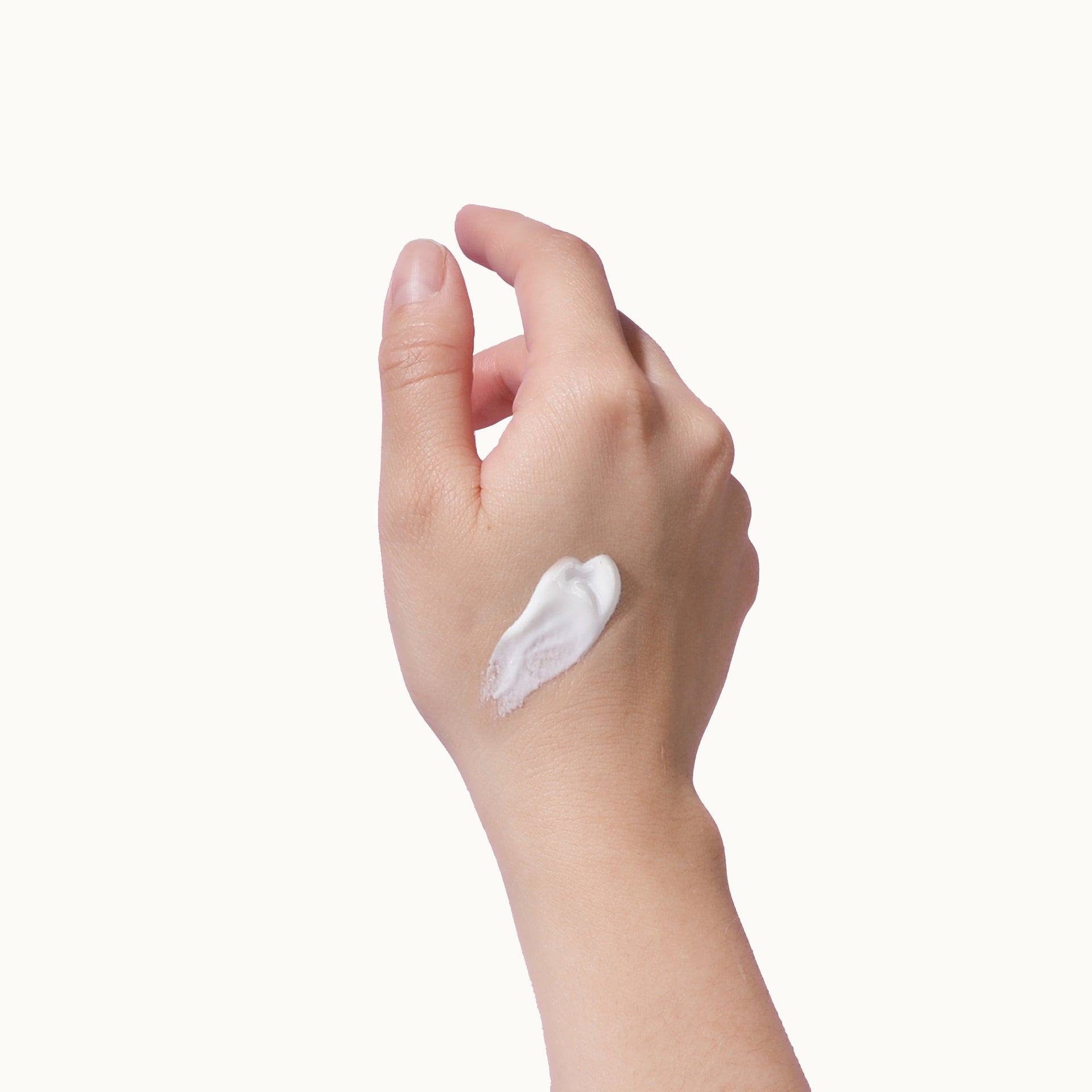 Hand applying Mama Sol FACEBRELLA™ moisturizing mineral sunscreen cream
