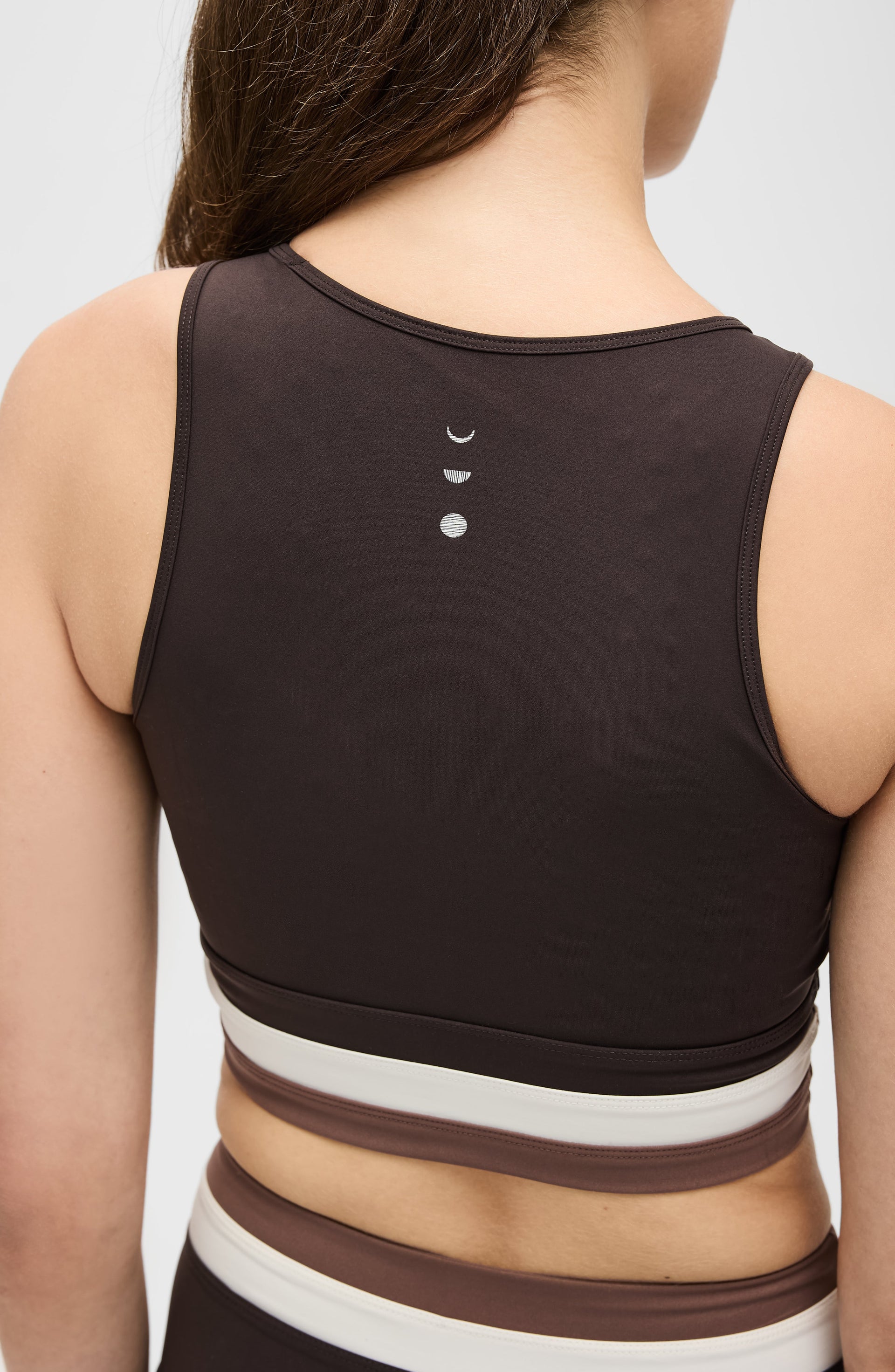 Back view of the Elastique Athletics Le Monde Bra in dark brown highlighting the racerback design and centered logo detail.