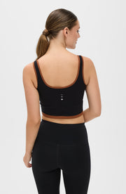 Back view of a woman wearing the Elastique Athletics Lisse Bra in black with matching biker shorts.