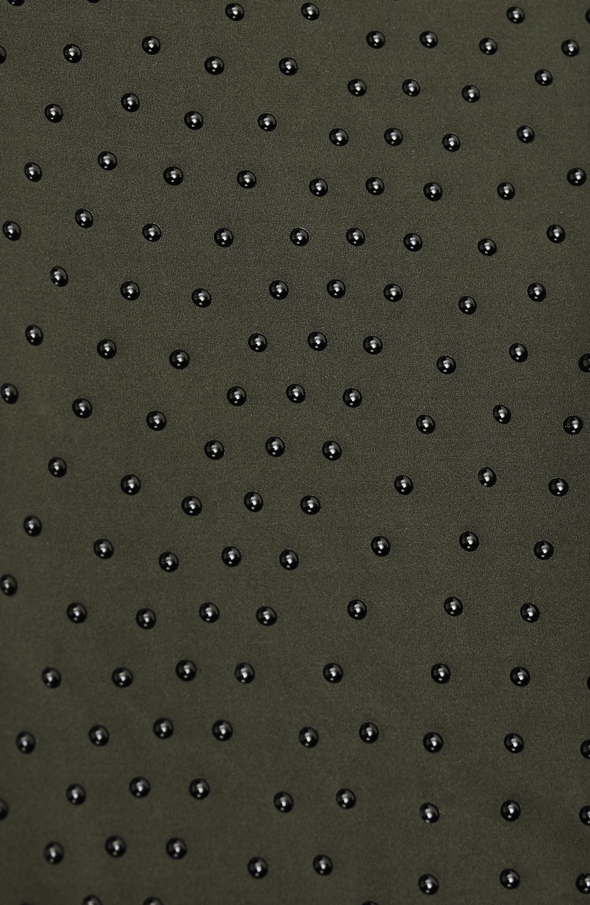 Close up texture detail of the Elastique Athletics Le Divine Lymphatic Bra fabric in olive green featuring a raised dotted compression pattern.