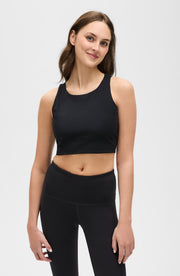 Full body studio portrait of a woman wearing the Elastique Athletics L'Original black sports bra and high waisted leggings.