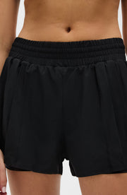 Close up front detail of the Elastique Athletics L'Original Flowy Short in black featuring an elastic waistband and lightweight fabric.