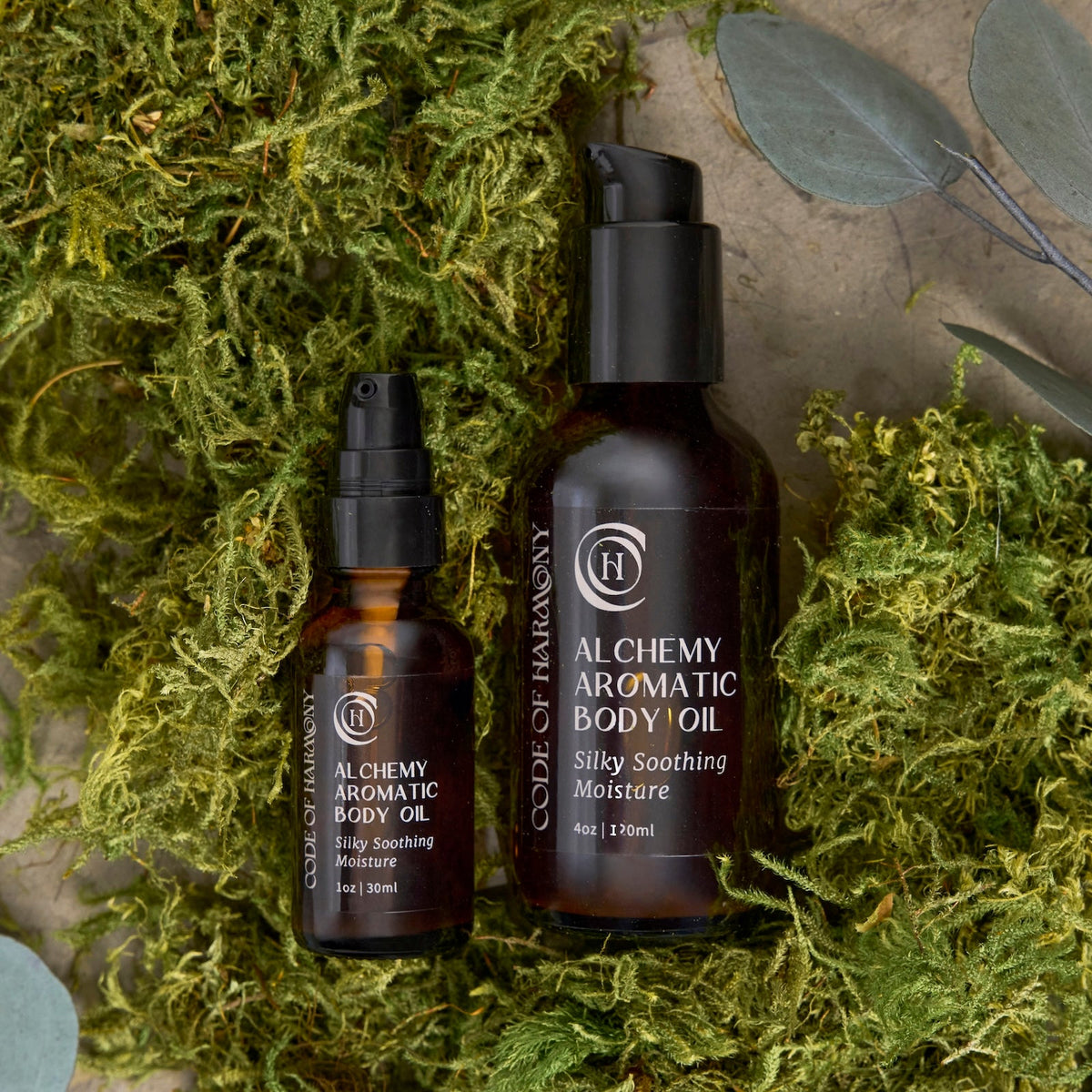 Code of Harmony Alchemy Aromatic Body Oil displayed on green grass
