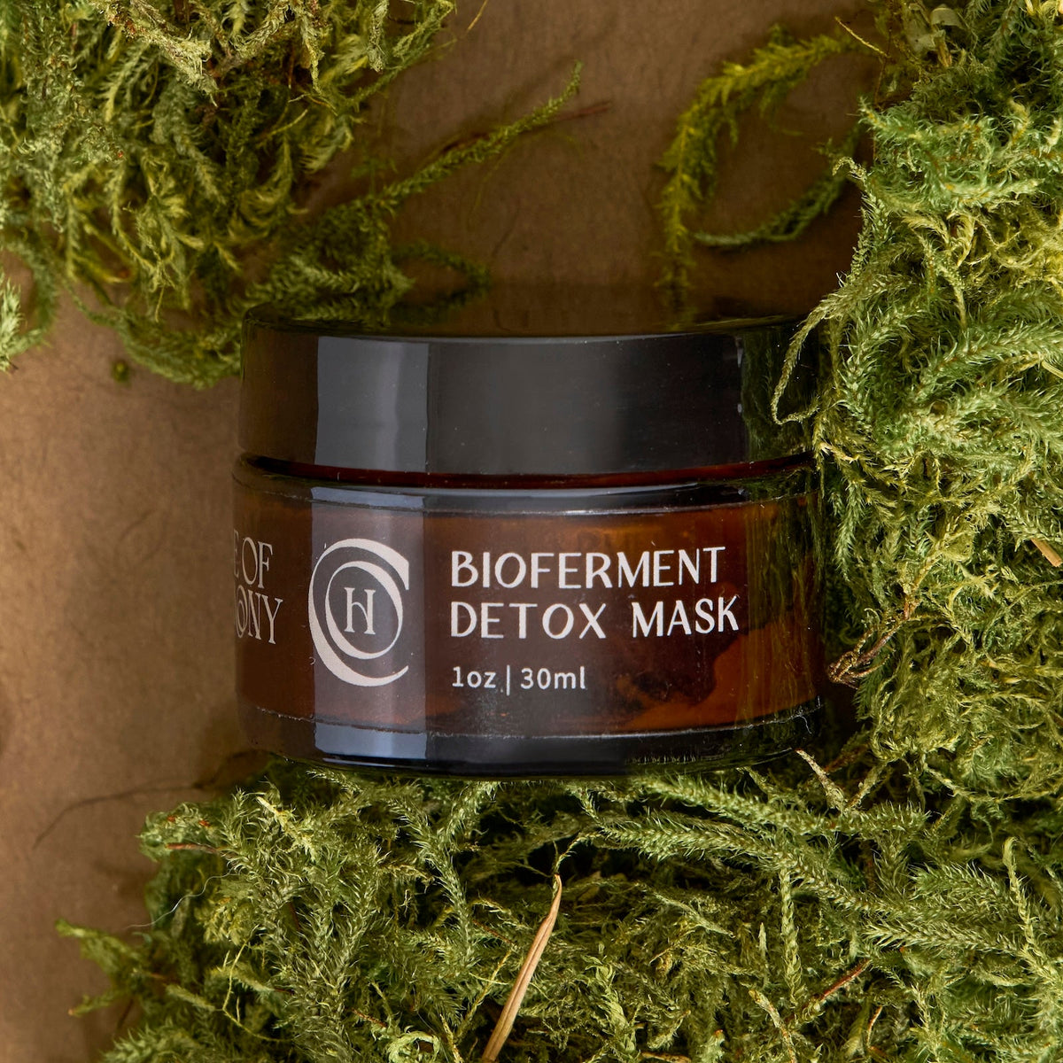 Code of Harmony Bioferment Detox Mask jar styled with green moss