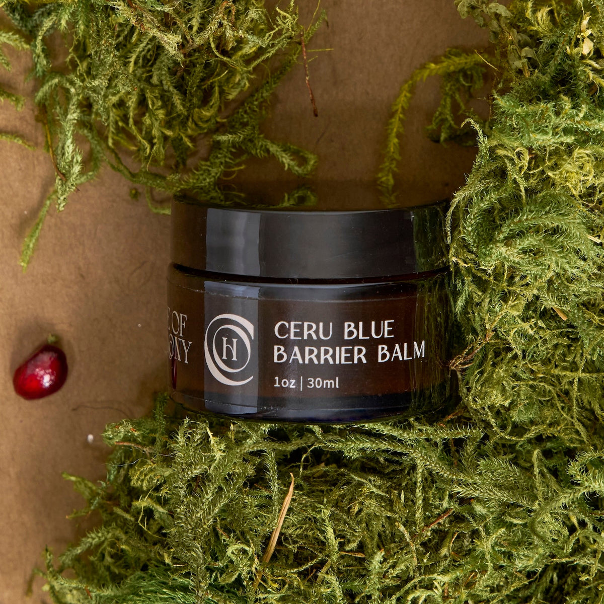 Code of Harmony Ceru Blue Barrier Balm jar styled with green moss