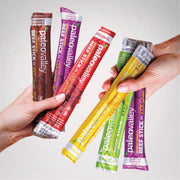 Hand holding variety pack of PaleoValley grass-fed beef sticks in different flavors