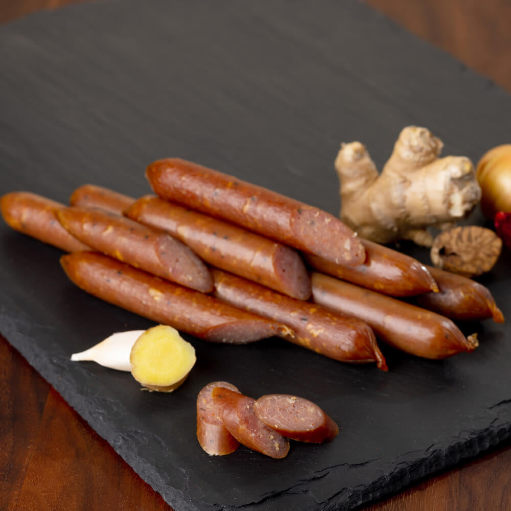 Pasture-raised chicken sticks on slate board with garlic and ginger ingredients