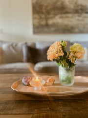 Busy Bees Glass Lantern set of 2 displayed on a wooden coffee table with flowers and soft candlelight in a warm neutral interior.